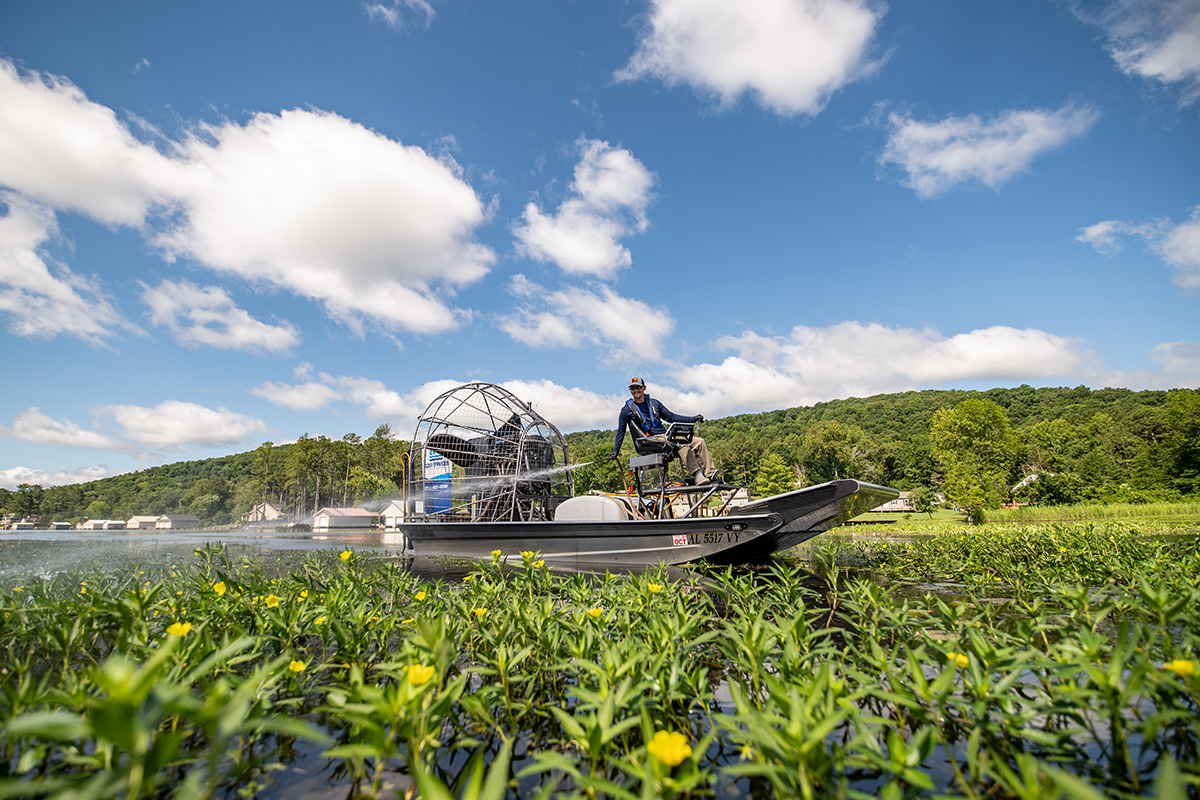 Man in airboat spraying weed control