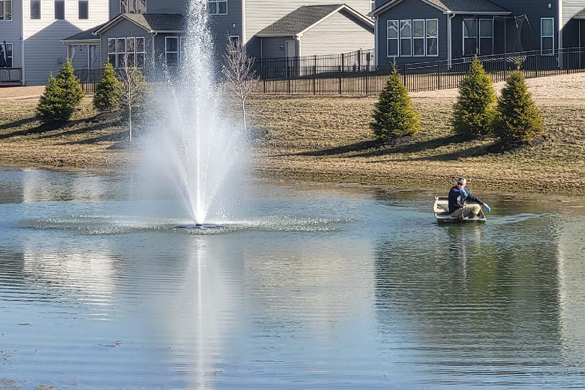 Man in boat inspecting fountain