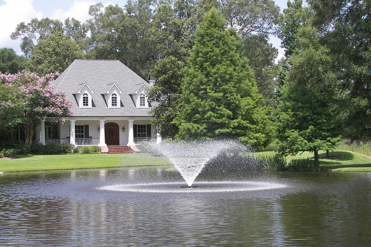 Pond fountain in front of home