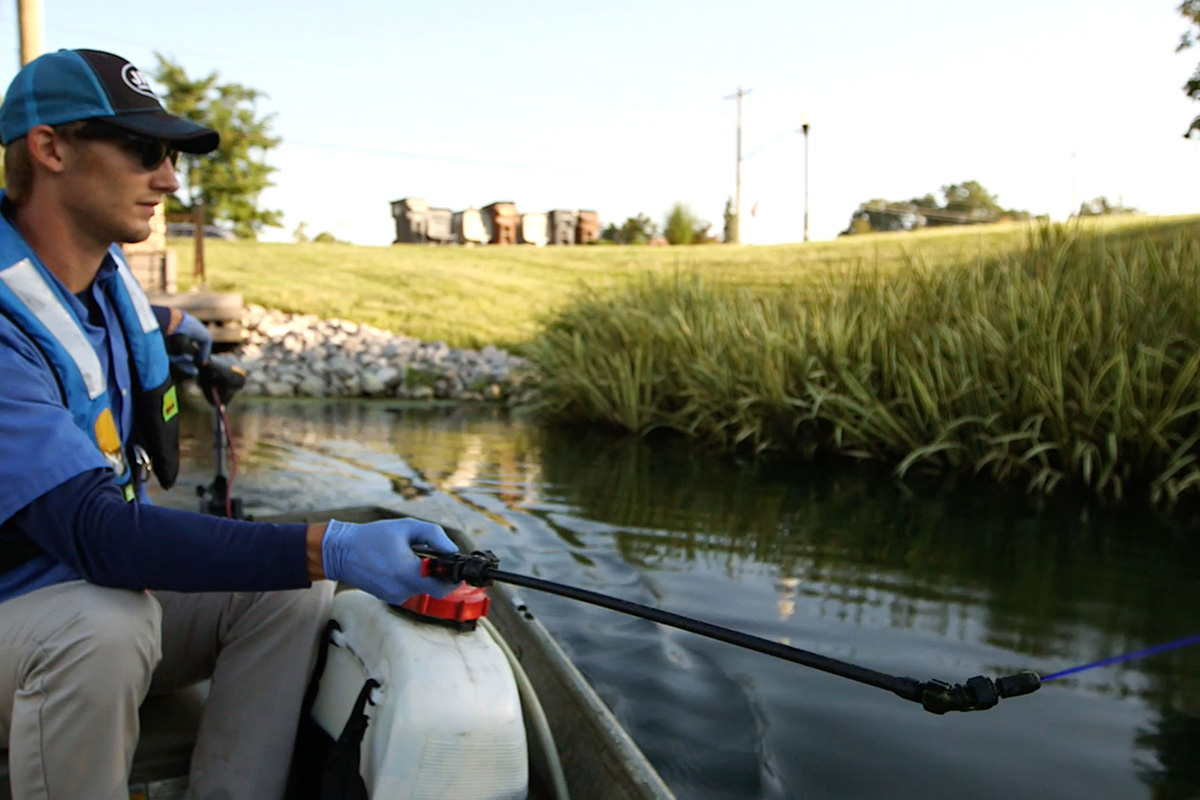 Man in boat applying nutrient treatment