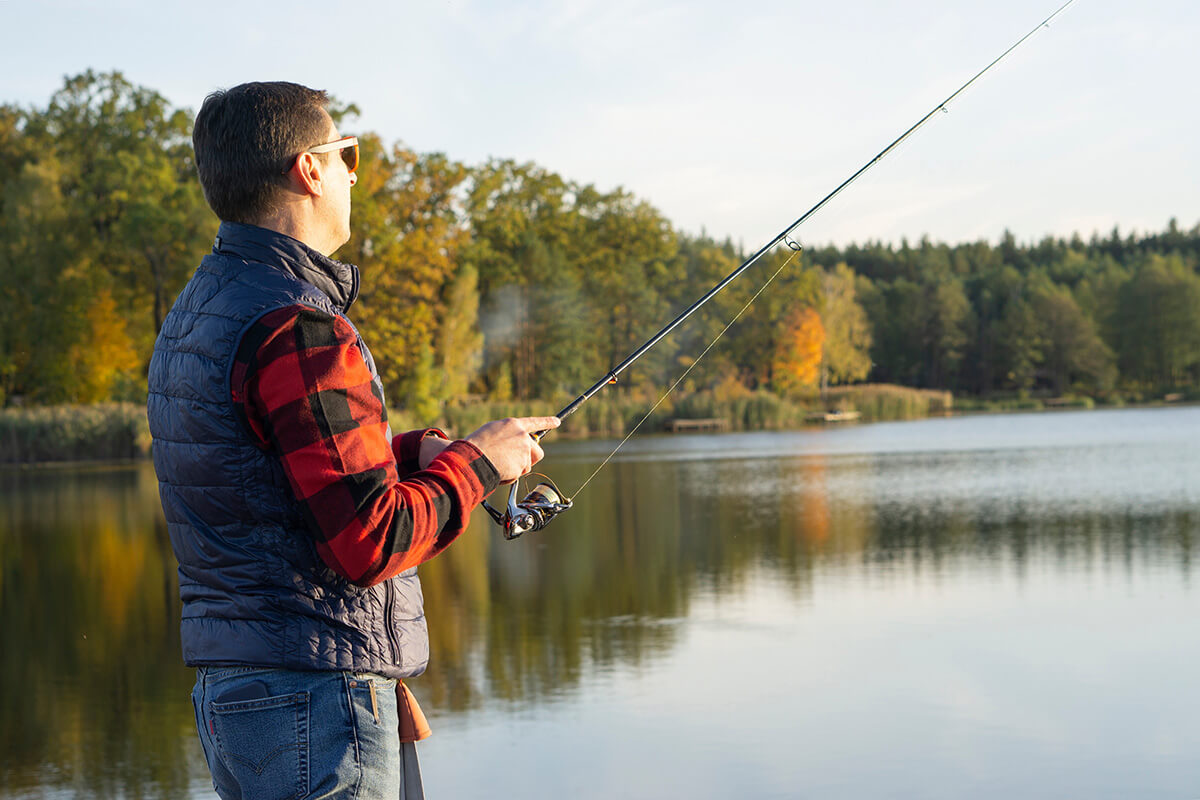 Man fishing in lake during Fall