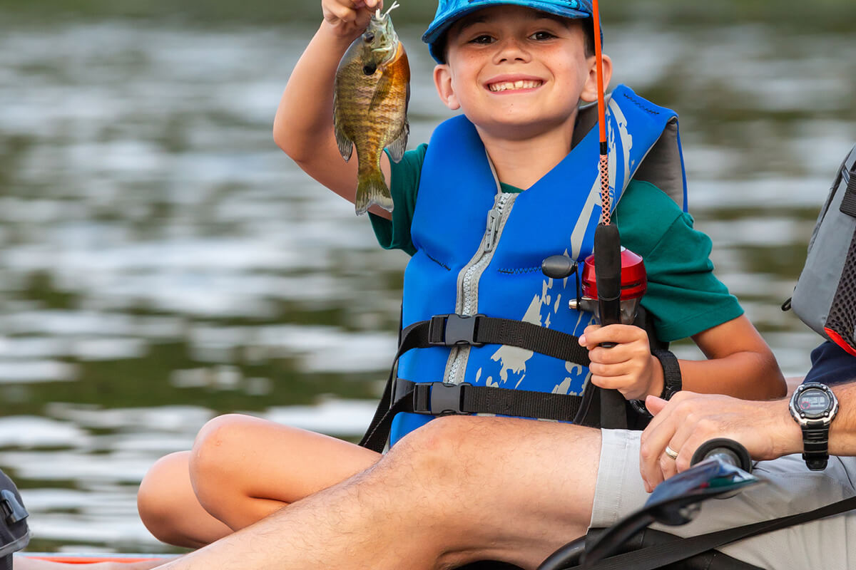 Child with fish on pole