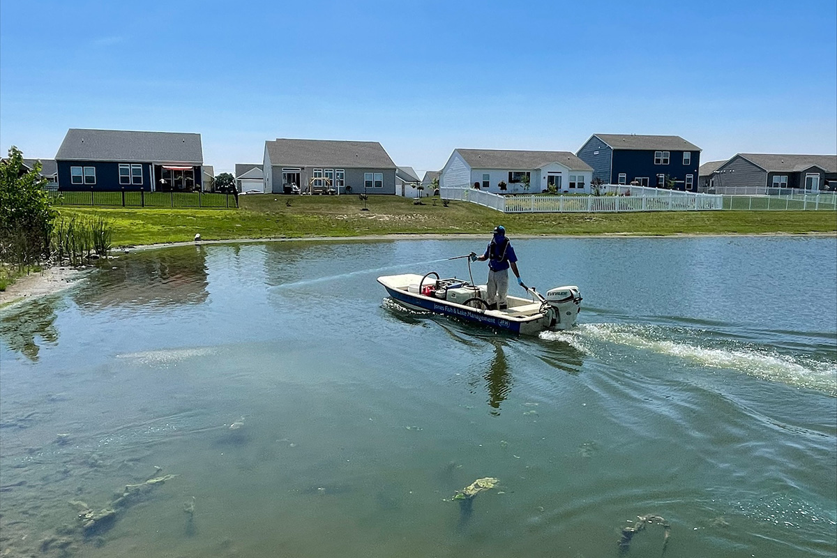 Man in boat applying water treatment